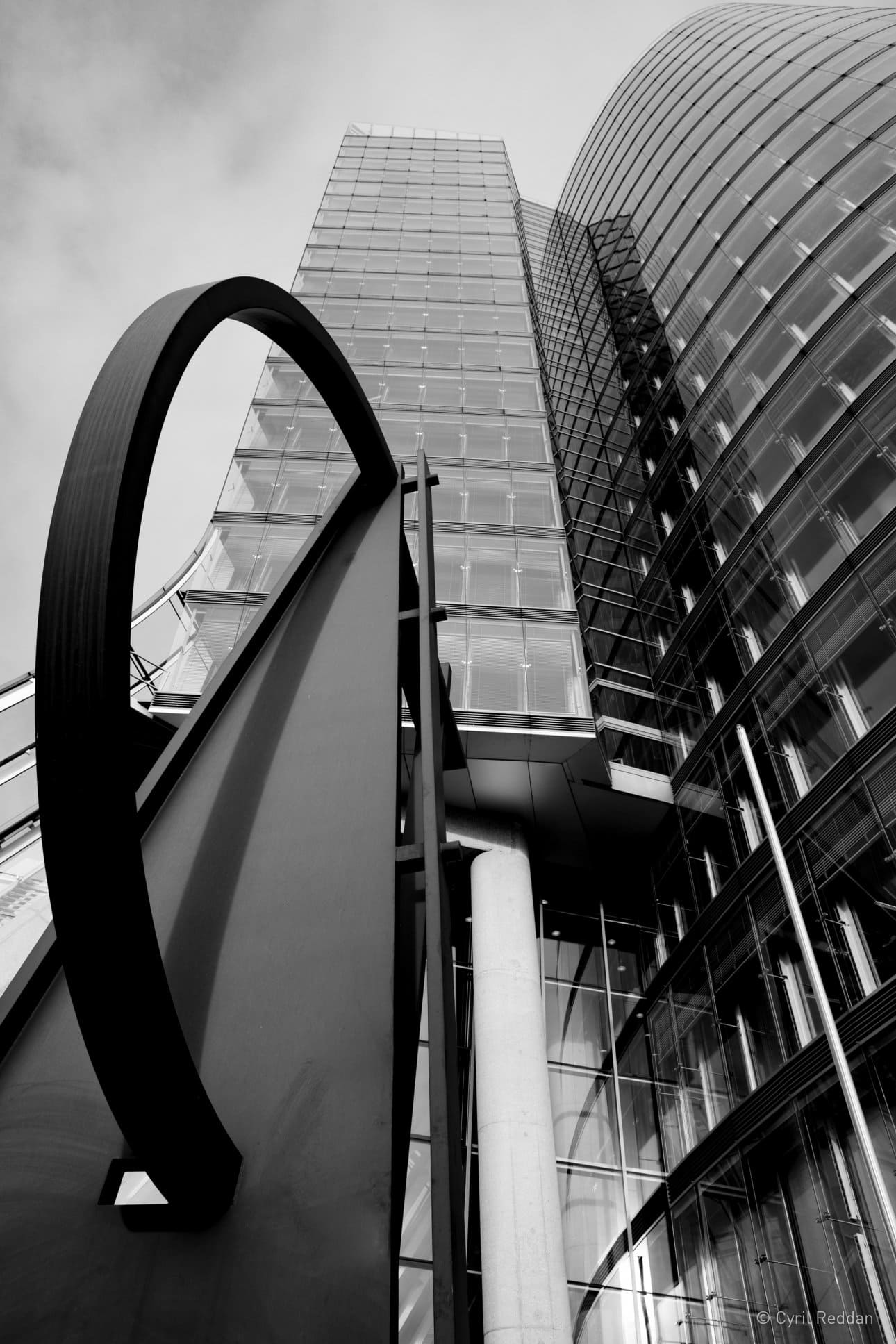Black and white photo looking up at the sculptural architectural design of the Uniqa Tower